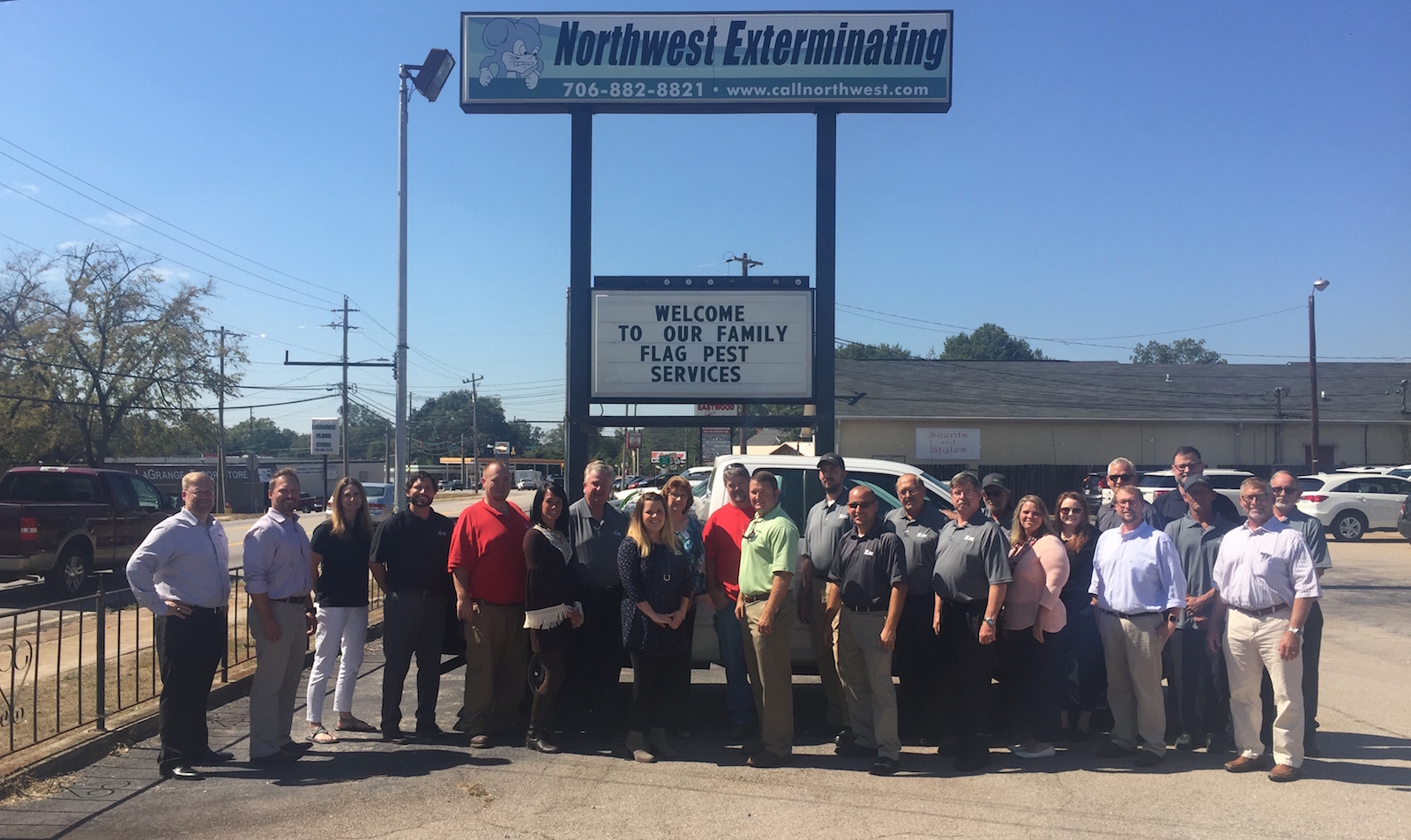 flag pest services staff standing in front of the company sign