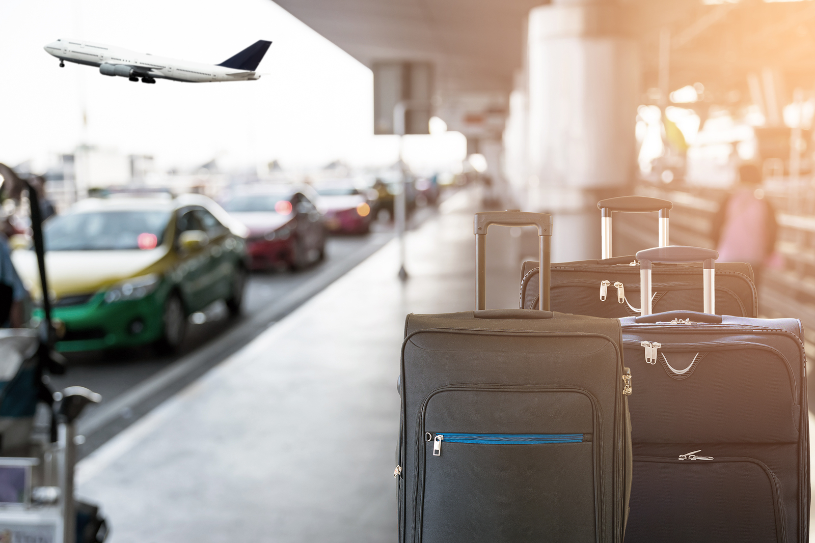 suitcases sitting outside of a busy airport