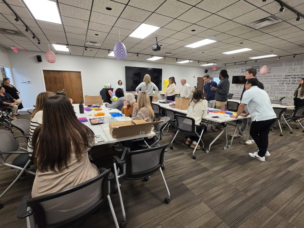Northwest Exterminating teammates gathered around tables filling plastic eggs together at a Good Deed Team community service project.